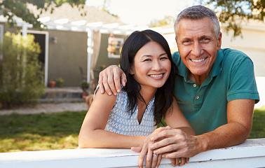 Image of couple with young child in front of home