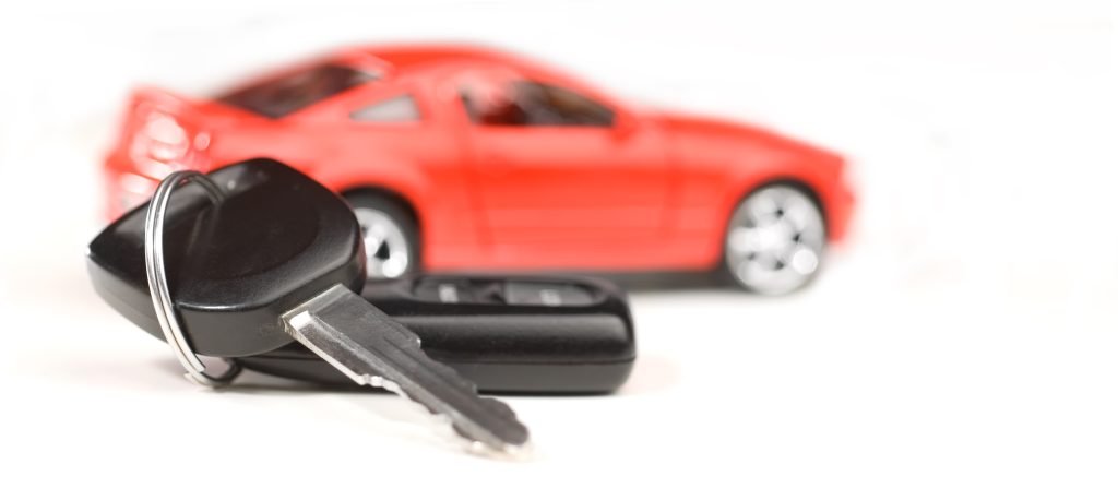 Car keys in front of a red car