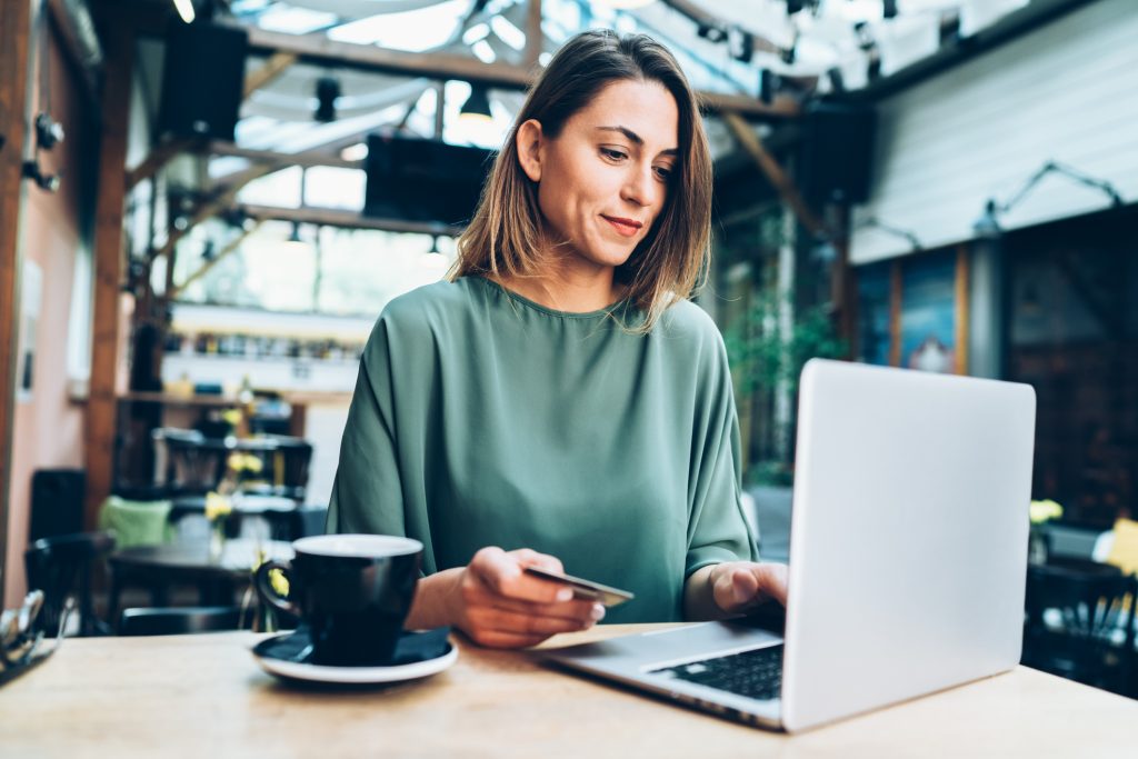 Young woman using credit card on her laptop.