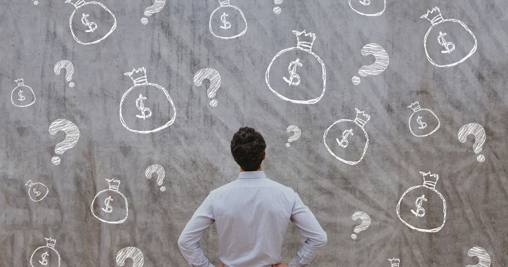 Man looking at wall with question marks and dollar signs.